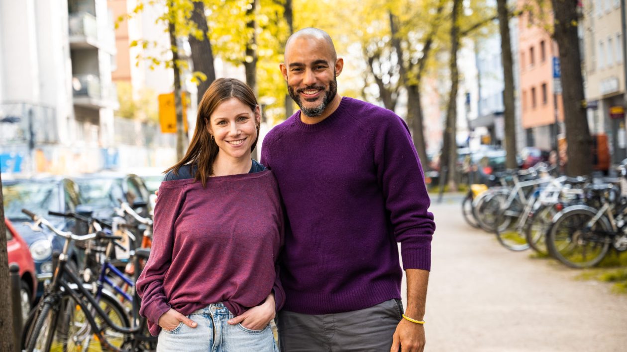 Schauspielerin Katrin Heß und Autor Beni Tonka stehen auf einer Straße in Köln und schauen in die Kamera