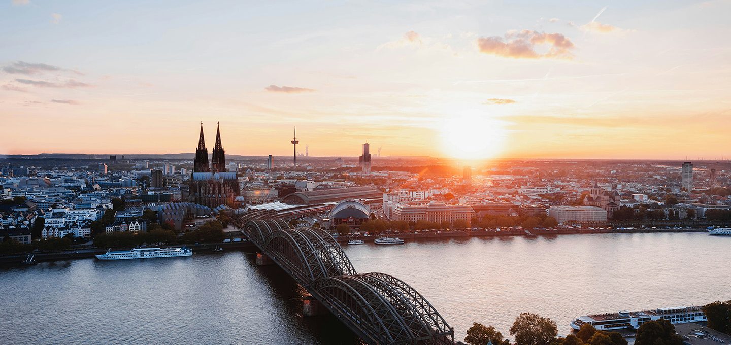 Die Skyline von Köln mit Blick auf die Hohenzollernbrücke und den Kölner Dom mit Sonnenuntergang.